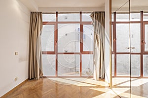 Empty bedroom with no view glass wall, red anodized aluminum windows and wardrobe with mirror doors and lock