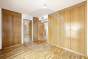 Empty bedroom with white aluminum windows, oak parquet flooring