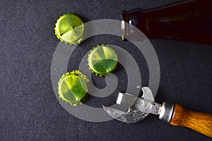 Empty beer bottle opener and gold bottle caps