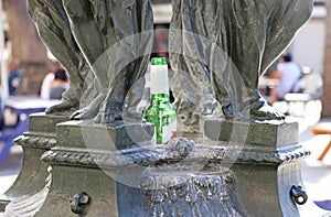 An empty beer bottle is placed inside a statue.