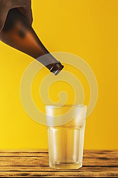 Empty beer glass, bottle beer on a wooden background and yellow, selective focus.