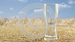 An empty beer glass stands to the right against a blue sky surrounded by malt