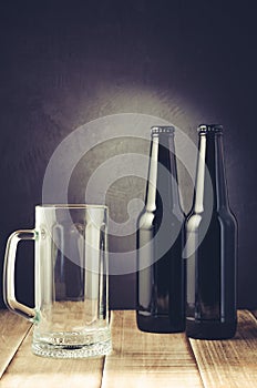 empty beer mug and bottle/ empty beer mug and bottle on a dark style. Selective focus