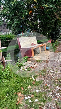 Empty Bench on the Bank of a Small River