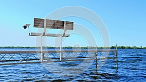 Empty bench on a boat dock on a lake with blue water and gentle waves