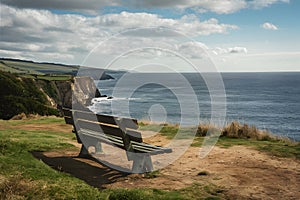 Empty bench on cliff overlooks peaceful sea, ideal for solitude