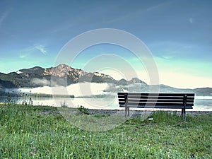 Empty bench at the lake beach. Magnificent lake in South Bavaria, Germany.
