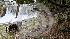 Empty bench at the Millcroft waterfall in Caledon, Ontario, Canada. This waterfall is located in a tourist resort photo