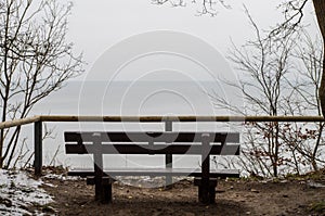 Empty bench on the shore of the ocean on a winter day