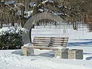 Empty bench on the street outside in the park in winter. Urban background. Rest and relaxation