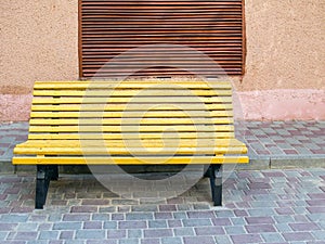 Empty bench in the street outside. Urban background. Rest and relaxation