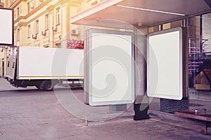 Empty billboards, advertising placeholder on a public bus stop, truck behind near house, mockup of a blank white poster.