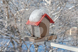 Empty bird feeder with no food inside and covered with snow. Concept, help for small city birds to survive during winter season