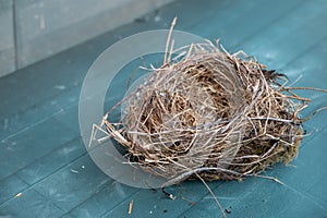 Empty bird nest made of twigs and dry grass on a blue background, copy space, selected focus