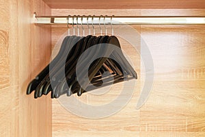 Empty black clothing rack hanging on coathanger in closet photo