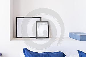 Empty black frames, posters, white canvas, mock up on a white wall, bedroom, gallery template