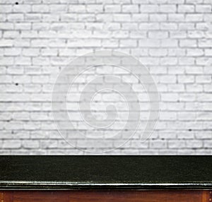 Empty black marble table and white brick wall in background