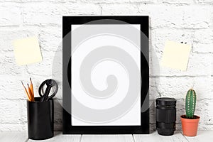 Empty black photo frame on wooden shelf or table. Mockup with copy space.