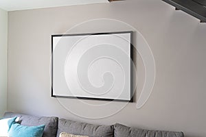 Empty black square frame, poster, white canvas mock up on a gray wall, living room template angle view