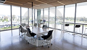Empty black swivel chairs arranged around desk in modern office