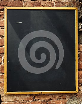 Empty blackboard on brick wall