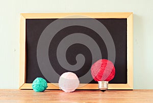 Empty blackboard and bulb idea concept made from wool balls