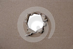 Empty blank cardboard form, craft paper, hole with roughly torn edge, concept of secrecy, tracking, spying, blank for the designer