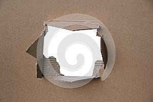 Empty blank cardboard form, craft paper, a hole with a straight cut and roughly torn edge, concept of secrecy, tracking, spying,