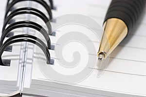 Empty blank ring, spiral notepad, gold pen closeup