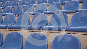 Empty bleacher in sports stadium. Blue seats in street stadium. Close up.