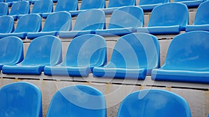 Empty bleacher in sports stadium. Blue seats in street stadium. Close up.