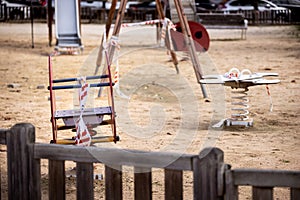 Empty blocked children playground with caution tape in residential area of Spain