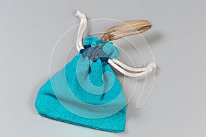 Empty blue fabric pouch with rope closure on gray background