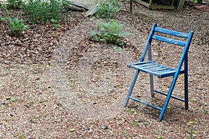 Empty blue folding chair outdoors, copy space, death grief absence concept