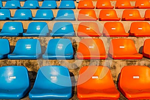 The empty blue and orange stadium seat.