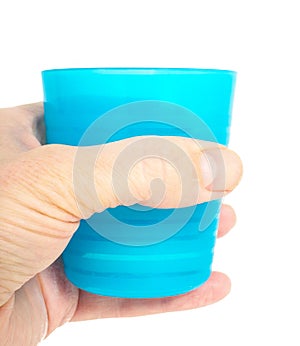 Empty blue plastic glass, held in a male persons hand