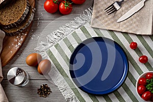 An empty blue plate as serving on the table.