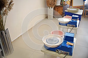 An empty blue potter`s wheel is prepared for the group practice of lepui pottery from clay. Tools for making clay products in a