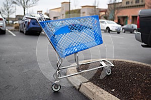 Empty blue shopping cart on the parking lot