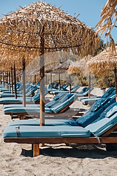Empty blue sun beds under the umbrellas on a beach in Mykonos, Greece