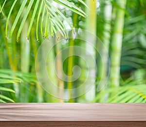 Empty board or table top and blurred green bamboo culms. Place for your product display