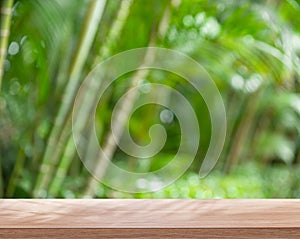 Empty board or table top and blurred green bamboo culms. Place for your product display