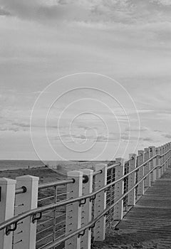 Empty boardwalk rises above the beach photo