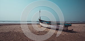 Empty boat on sandy beach in bright day. Large old white boat on sandy seaside ready to sail in bright day on beach