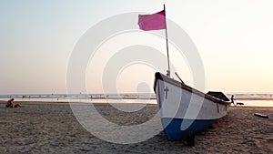 Empty boat on sandy beach in bright day. Large old white boat on sandy seaside ready to sail in bright day on beach