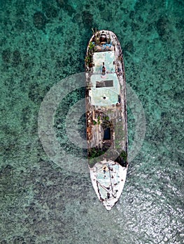 an empty boat in a turquoise ocean is surrounded by grass