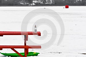 Empty Bottle on Picnic Table by Lake, Sled, Ice Fishing