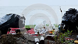 Empty bottles and containers polluting seashore, tons of garbage damaging nature