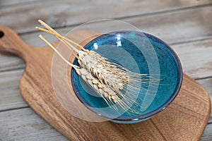 An empty bowl and a few ears of wheat