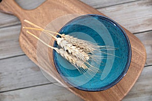 An empty bowl and a few ears of wheat